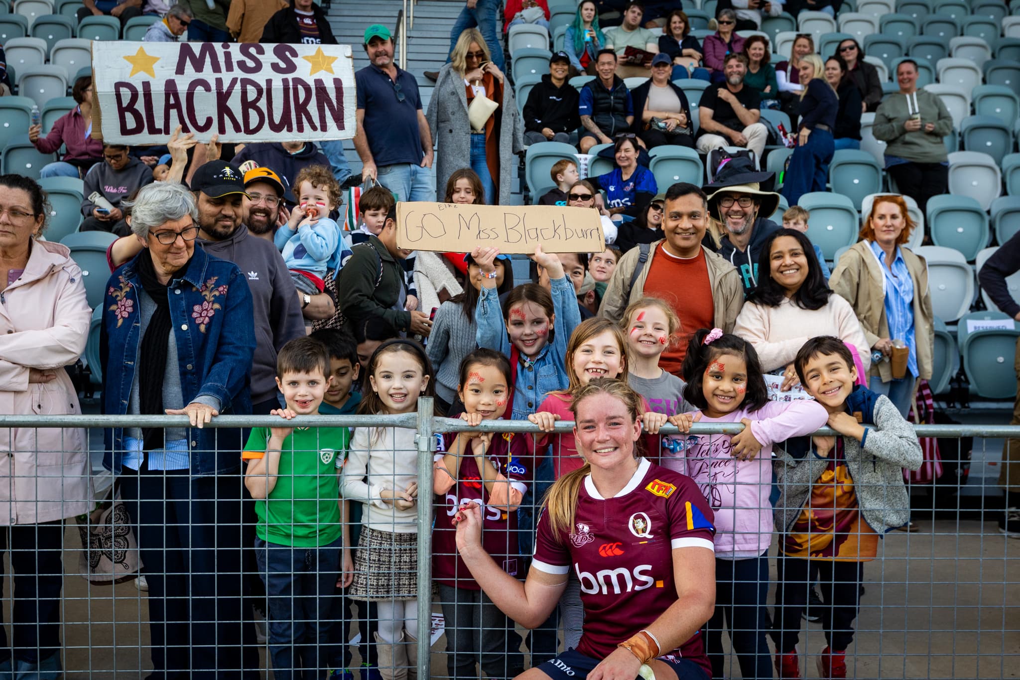 Reds forward Dillyn Blackburn with her fan club from Toowong State School where she is a schoolteacher