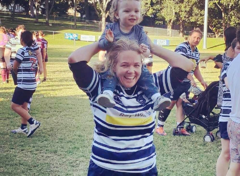 New QRU Vice-President Jenny Gillett celebrates her 100-game milestone for Brothers with daughter Florence in 2018