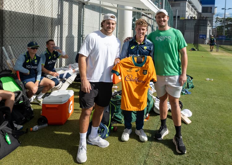 Fraser McReight (left) and Harry Wilson present opener Nathan McSweeney with a Wallabies jersey before the cricket Test at the Gabba