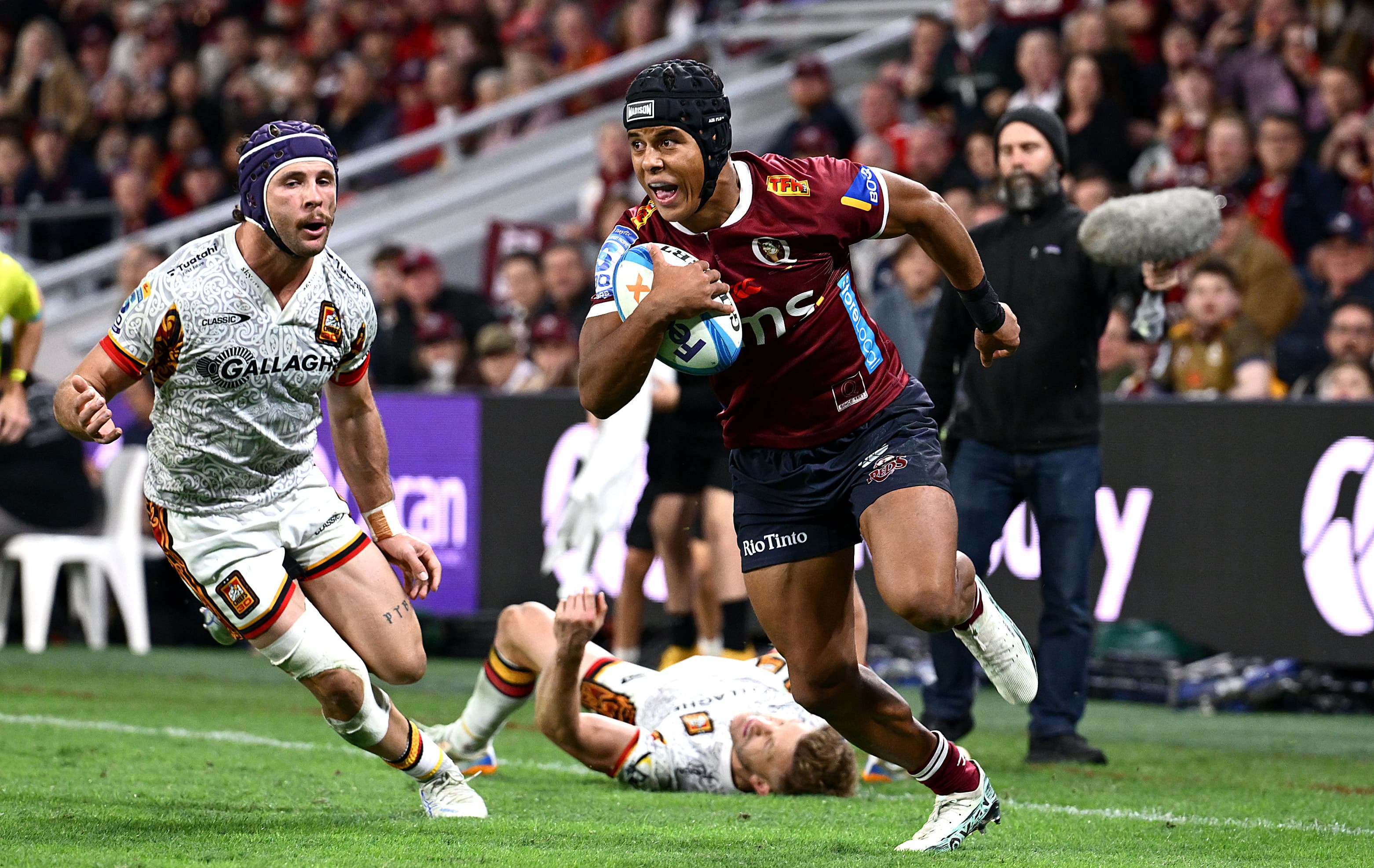Reds winger Treyvon Pritchard en route to his first Super Rugby try after some dazzling footwork to shed Chiefs defender Damian McKenzie. Photo: Bradley Kanaris, Getty Images
