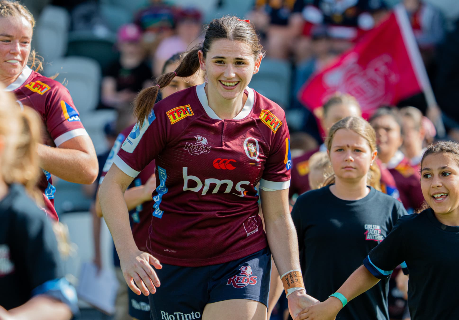 Reds No.8 Zoe Hanna running out with a junior mascot at Ballymore